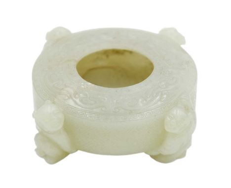 A Chinese celadon jade 'four boys' water pot, Qing Dynasty.  Of circular form, the top carved with interlocked stylised chilo