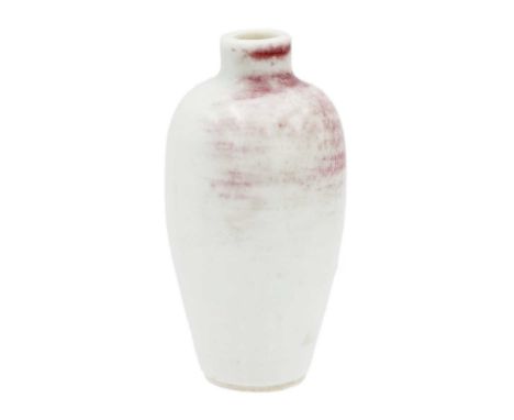 A Chinese peach bloom miniature baluster vase, 19th century. The reddish glaze shading to pale celadon, height 7cm, width 3.5