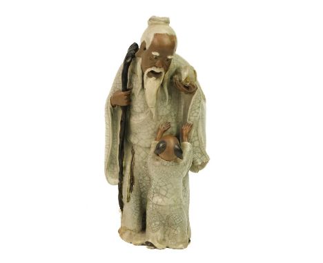 A Chinese Shiwan figure of a mudman and child, Qing Dynasty, 19th century. Signature to base, height 22cm, width 10cm, depth 