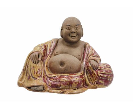 A Chinese pottery model of Buddha, 18th/19th century. The smiling Buddha in a large robe and reclining pose, height 12cm, wid