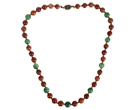 A Chinese green and russet jade bead necklace with silver filigree clasp. The largest bead is 13.5mm, smallest 11.1mm, length