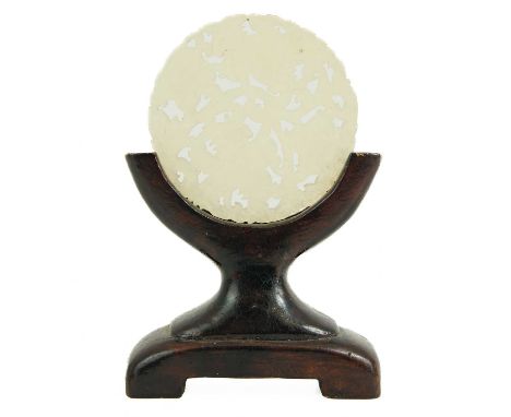 A Chinese jade bi type disc, early 20th century. Carved with foliage, diameter 5.1cm, on a wooden stand, total height 9.5cm.P
