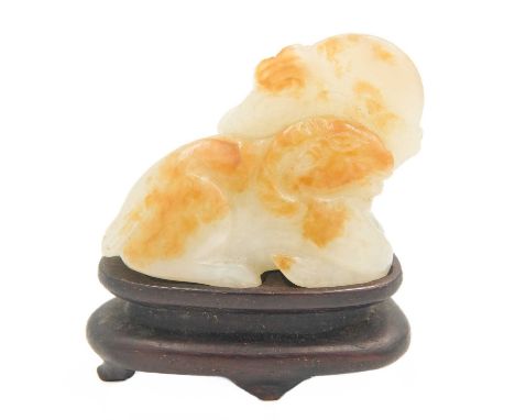 A Chinese carved jade model of a ram, Qing Dynasty, 19th century.  Height 4cm, width 5cm, depth 3cm, on a wooden stand, heigh