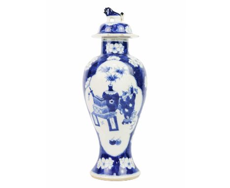 A Chinese blue and white prunus blossom porcelain vase, late 19th century. The cover surmounted by a dog of fo, above shaped 