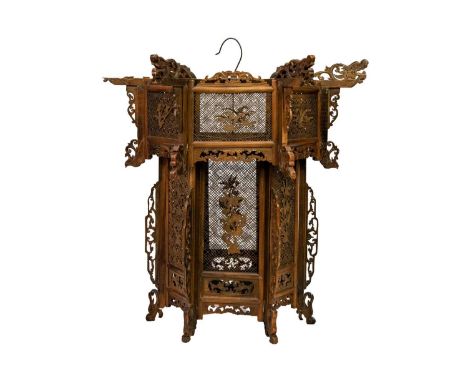 A Chinese boxwood pierced hanging lantern, early 20th century. With carved dragon masks above pierced panels with calligraphy