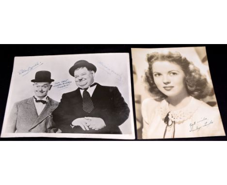 Stan Laurel and Oliver Hardy: a signed black and white photograph inscribed "Our Best Wishes Always Oswald", signed by both m