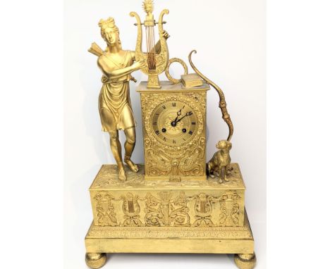 A French Empire ormolu clock, mounted with a maiden archer with harp and dog, Roman numerals, 8 day movement, raised above a 