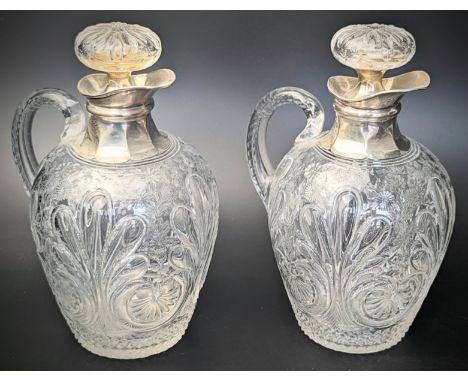 A pair of late Victorian silver and glass wine carafes, etched bodies in the Grecian style with floral splays, cut diamond pa