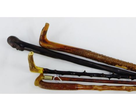 A collection of four Gentleman's wooden walking canes together with a horn handled swagger stick, 75cm long (5) 