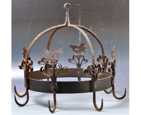 A contemporary antique style rustic hanging wrought iron chandelier / lighting fixture of domed rounded form with birds atop 