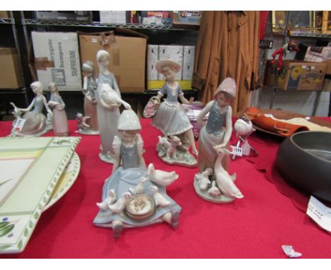 Four Lladro figurines: girl with a puppy, girl feeding ducks, girl feeding geese and girl with goose and puppy