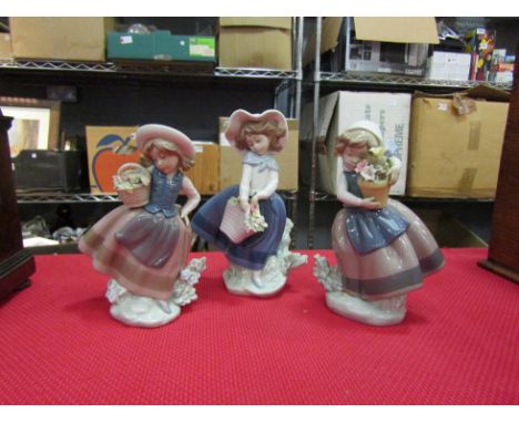 Three Lladro figurines depicting children with baskets of flowers