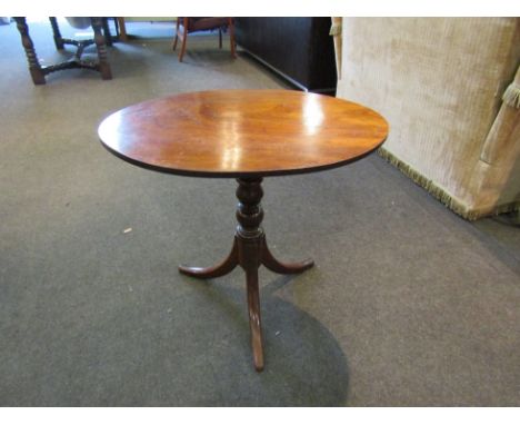 An early Victorian mahogany oval tilt-top wine table, turned column to outswept tripod base