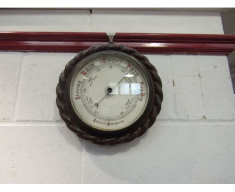 A circular aneroid barometer with rope twist detail