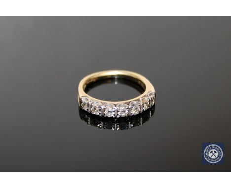 An 18ct gold seven stone diamond half eternity ring, the total diamond weight estimated at 0.65 carat, size M