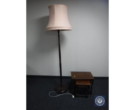 A nest of three oak tables together with a mahogany standard lamp with shade