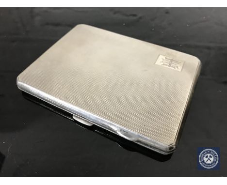 A silver cigarette case with engine turned decoration