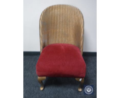 A gold Lloyd Loom basket chair