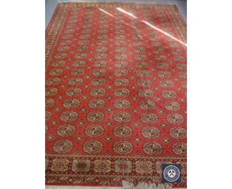 A 20th century machine made Persian design carpet on red ground 