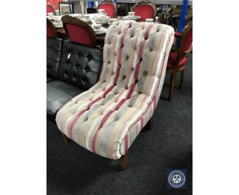A button back bedroom chair in multi coloured striped fabric. 