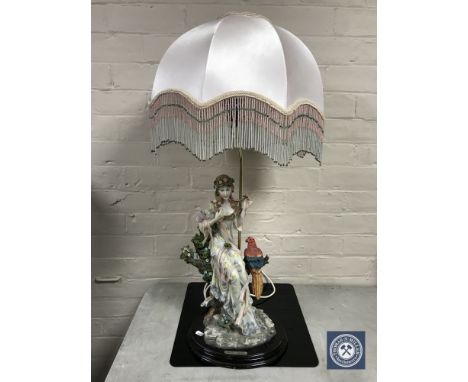 A Danielle Collection table lamp, lady seated on branch with parrot 