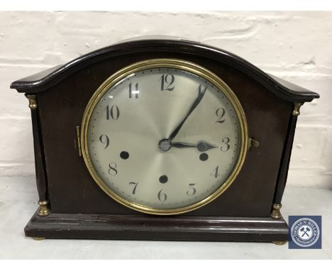 A mahogany cased mantel clock with pillar supports and silvered dial