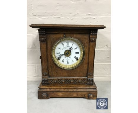 A carved oak cased bracket clock with enamelled dial, retailed Fattorini &amp; Sons of Bradford