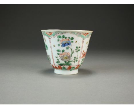 A Chinese famille verte cup, 18th Century, of inverted bell form and decorated with panels of 'Kakiemon' style flowers and fo