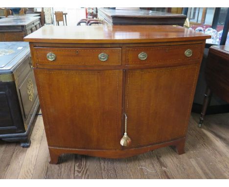 An early 19th century mahogany and chevron banded bowfront side cabinet, with two frieze drawers over a pair of panelled door