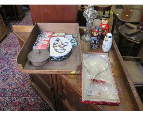 Three Russian dolls, a pair of calipers, a glass oil lamp, and various tin boxes 