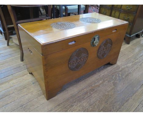 A Chinese camphorwood chest, carved with roundel designs, on bracket feet, lacks internal tray, 100 cm wide, 50 cm deep, 55 c