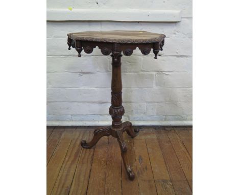 A Victorian oak tripod table, the octagonal top with turned pendants and roundels on an acanthus carved stem and cabriole leg