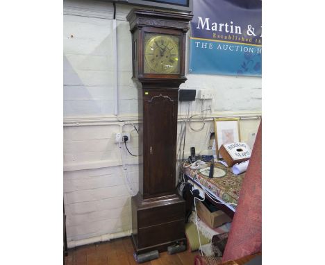 A George II oak longcase clock, the blind fret carved frieze over a brass dial with urn spandrels, and engraved matted centre