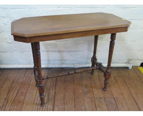 An Edwardian mahogany side table, the canted rectangular top on ring turned tapering legs joined by stretchers, 91 cm wide, a