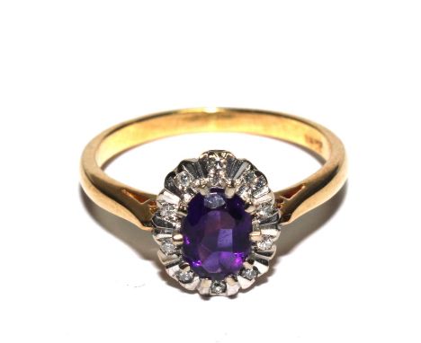 An amethyst and diamond cluster ring set in 18 carat gold 