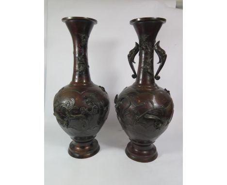 A pair of Japanese bronze vases, depicting cranes and birds in branches, one vase lacking twin handles, seal marks to the bas