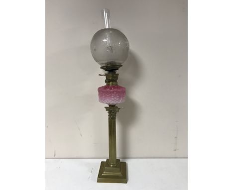 A Victorian oil lamp with pink glass bowl