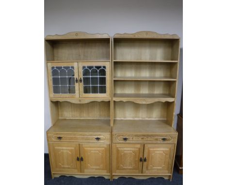 A two section light oak bookcase with drawers and cupboards below 