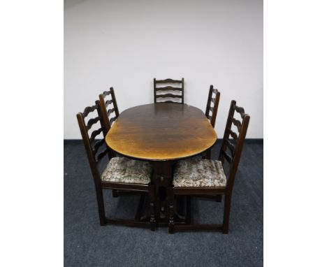 An oak extending dining table and five ladder back chairs 