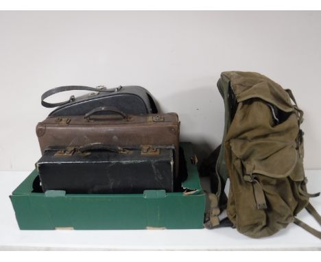 A canvas rucksack containing leather satchel etc, vintage suitcases, travel case