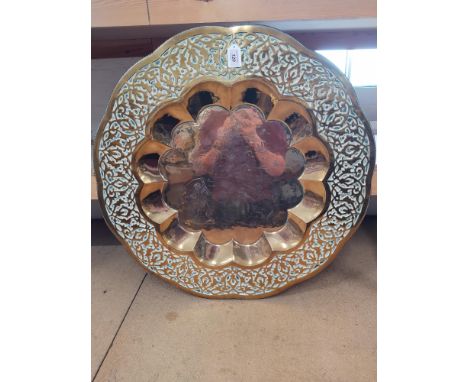 A large brass charger decorated with an Indian hunting scene, approx 30" in diameter