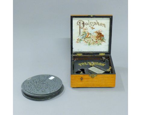 A walnut cased polyphon and discs. 18.5 cm squared.