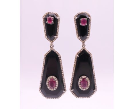 A pair of black onyx, diamond and ruby earrings. 5 cm high.