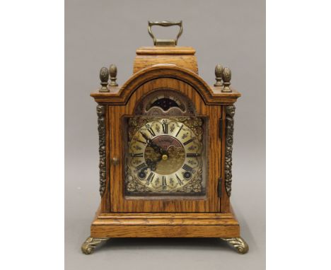 A small oak mantle clock. 23 cm high.
