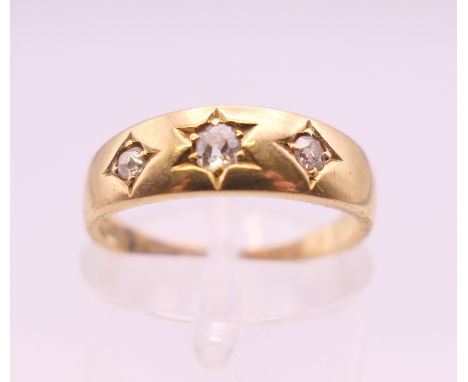 An 18 ct gold three stone gypsy set diamond ring. Ring size K. 3 grammes total weight.