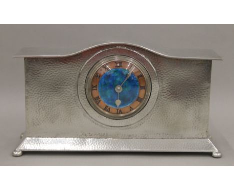 A Liberty &amp; Co Tudric pewter mantle clock, with enamel dial. 32 cm wide.