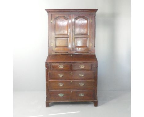 A George I provincial oak bureau bookcase, the top section with single shelf and 3 drawers (2 blind), the bureau section with