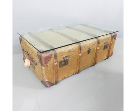 A glass-top coffee table, the base being a vintage trunk. 94x35x54cm.