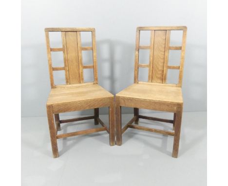 A pair of Arts and Crafts oak hall chairs with panel and lattice back in the manner of Heals.