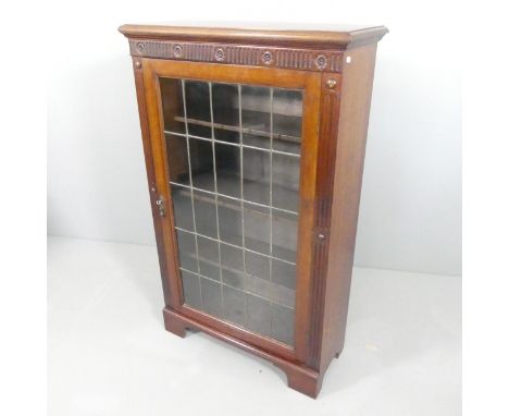 A mahogany bookcase with single leadlight panel door, carved decoration and 3 adjustable shelves.